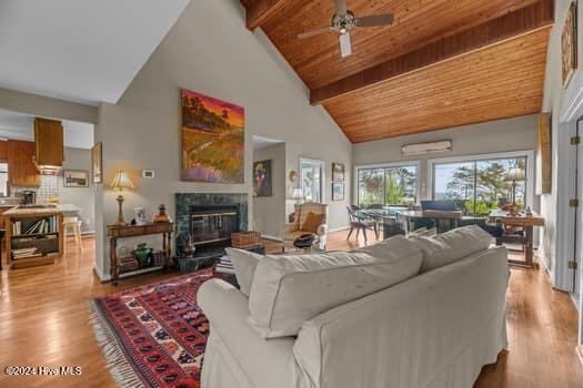 living room with high vaulted ceiling, ceiling fan, a premium fireplace, beam ceiling, and wood ceiling