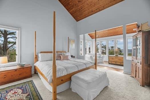 bedroom featuring light colored carpet, wood ceiling, high vaulted ceiling, and multiple windows