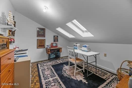 office space featuring parquet floors and lofted ceiling with skylight