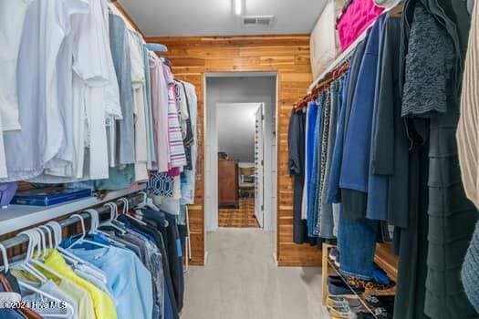 walk in closet featuring light carpet