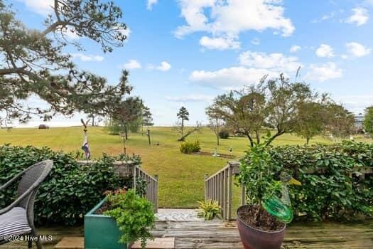 wooden terrace featuring a lawn