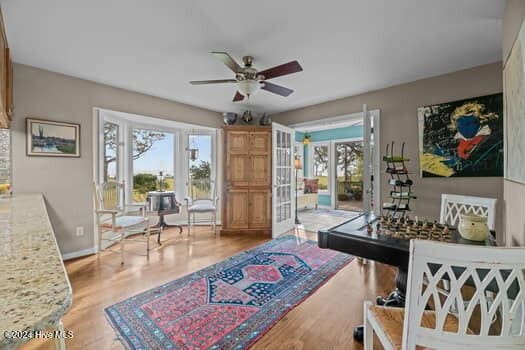 recreation room with ceiling fan, light hardwood / wood-style floors, and french doors