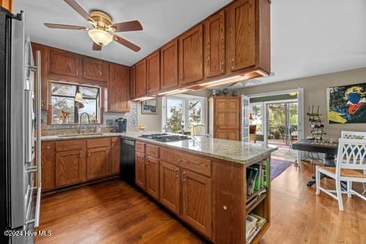 kitchen featuring ceiling fan, sink, kitchen peninsula, light hardwood / wood-style floors, and appliances with stainless steel finishes