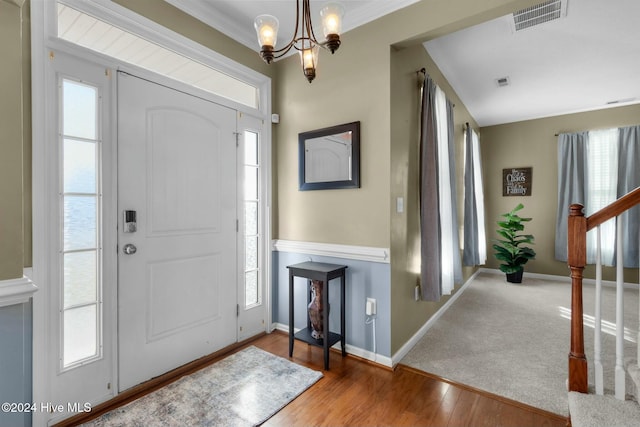 foyer featuring hardwood / wood-style flooring, a healthy amount of sunlight, and crown molding