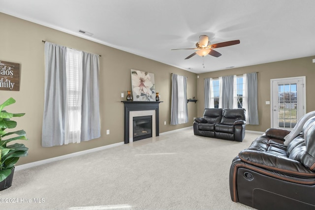 carpeted living room with ceiling fan