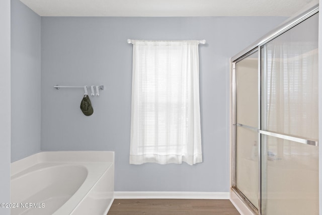 bathroom with wood-type flooring and separate shower and tub