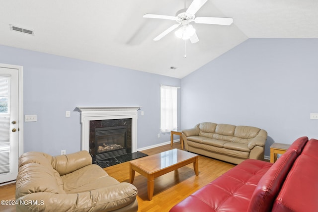 living room with ceiling fan, light hardwood / wood-style floors, vaulted ceiling, and a healthy amount of sunlight