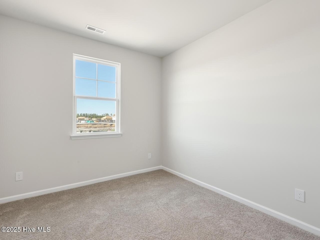 unfurnished room featuring carpet floors, visible vents, and baseboards