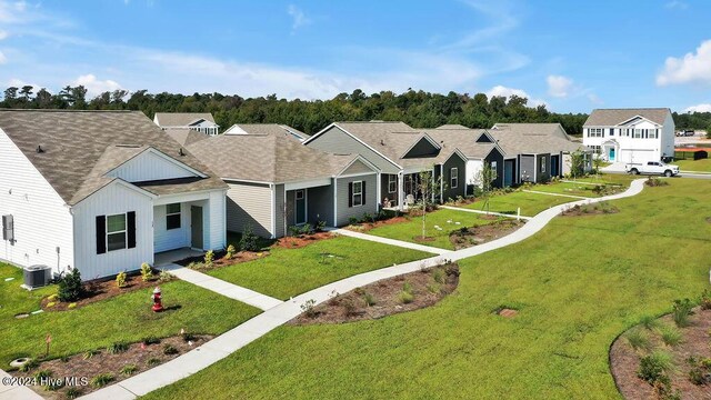 view of front of house featuring a residential view, a front lawn, board and batten siding, and roof with shingles