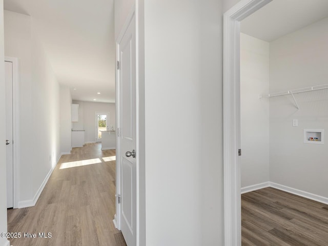 corridor with light wood-type flooring and baseboards