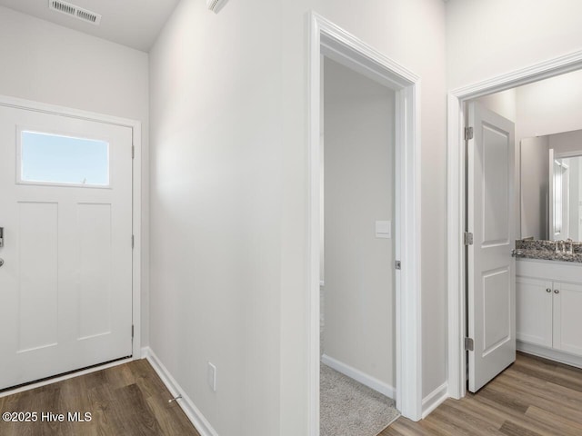 entryway featuring a healthy amount of sunlight, visible vents, light wood-style flooring, and baseboards