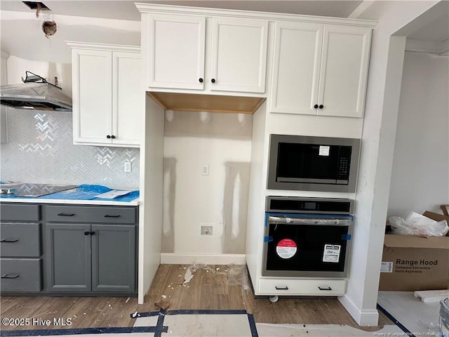 kitchen featuring white cabinetry, stainless steel microwave, oven, gray cabinets, and black electric stovetop