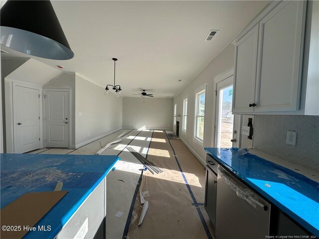 interior space featuring dishwasher, decorative backsplash, and ceiling fan with notable chandelier