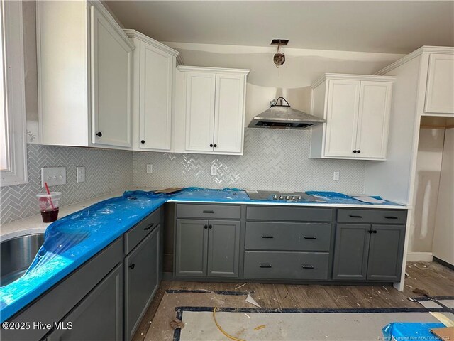 kitchen featuring stovetop, pendant lighting, gray cabinets, and white cabinetry