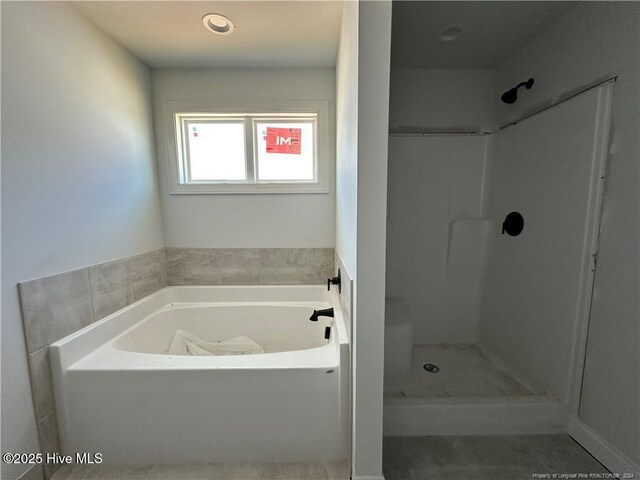 bathroom featuring tile patterned floors and independent shower and bath