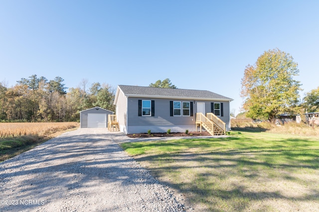 view of front of home featuring a front lawn, an outdoor structure, and a garage