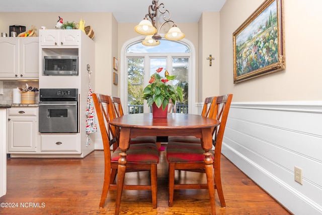 dining room with a notable chandelier and dark hardwood / wood-style flooring