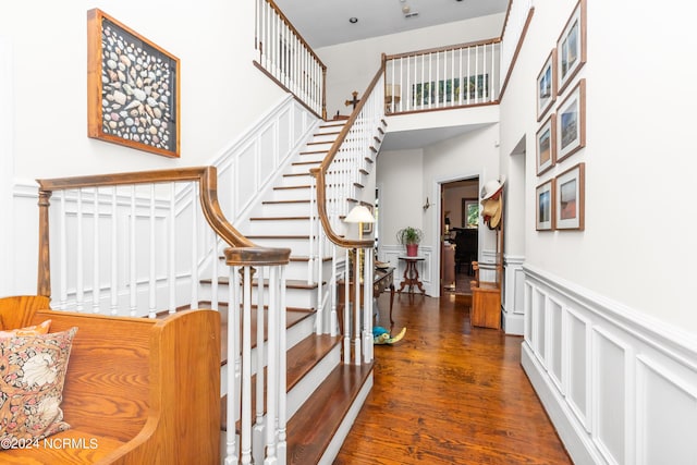 stairway featuring hardwood / wood-style flooring and a high ceiling