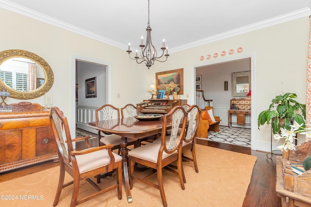 dining space featuring wood-type flooring, a chandelier, and crown molding