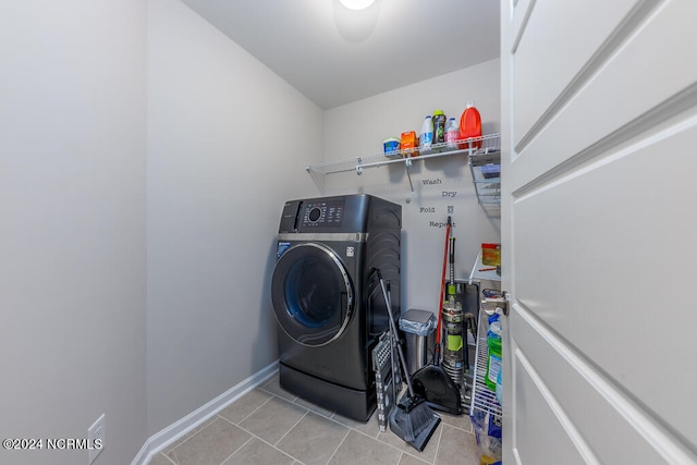 clothes washing area featuring washer / clothes dryer and light tile patterned flooring