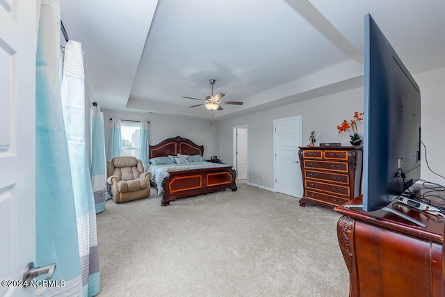 bedroom with a tray ceiling, ceiling fan, and carpet floors