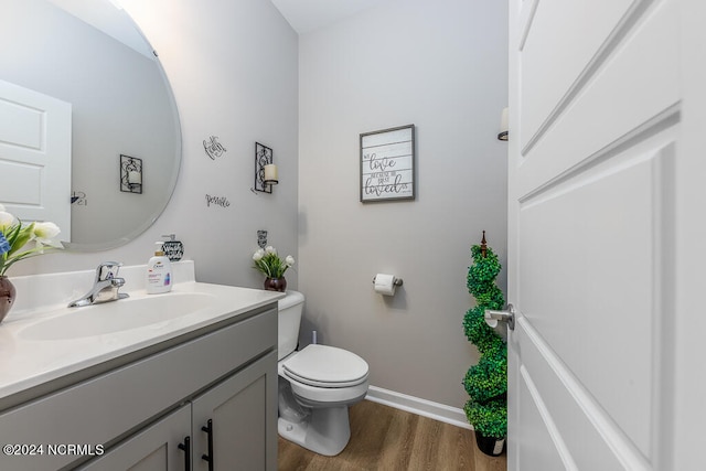 bathroom featuring wood-type flooring, vanity, and toilet