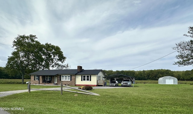 view of front of home featuring a carport, a storage unit, and a front lawn