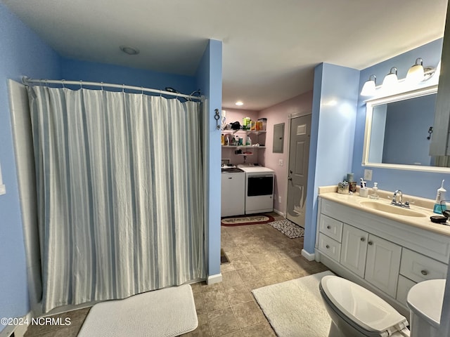 bathroom featuring independent washer and dryer, vanity, toilet, and curtained shower