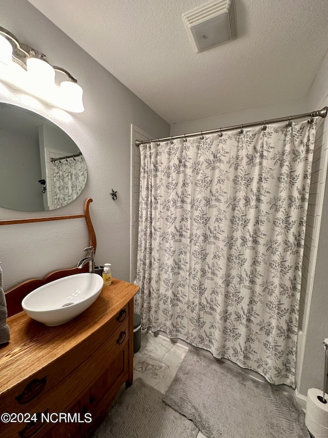 bathroom featuring vanity and a textured ceiling