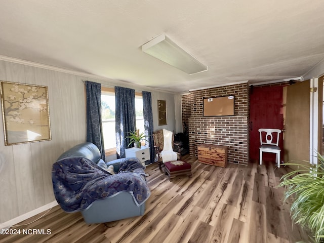 living area with ornamental molding and hardwood / wood-style floors