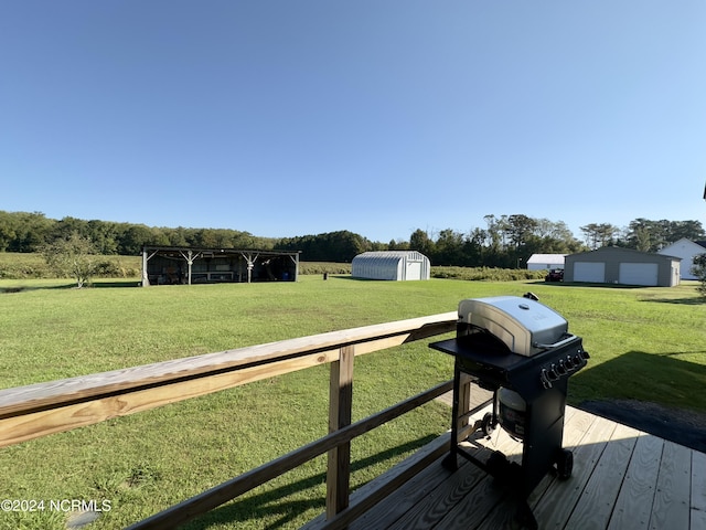 wooden terrace with a grill, a lawn, and a storage unit