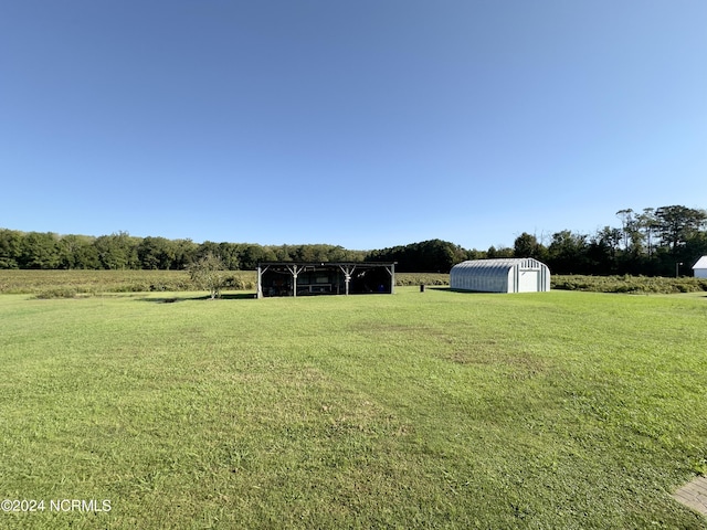 view of yard featuring a rural view and an outbuilding