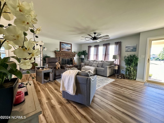 living room featuring a fireplace, light hardwood / wood-style floors, and ceiling fan