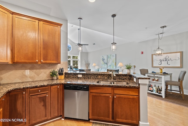 kitchen featuring light hardwood / wood-style flooring, pendant lighting, sink, and stainless steel dishwasher