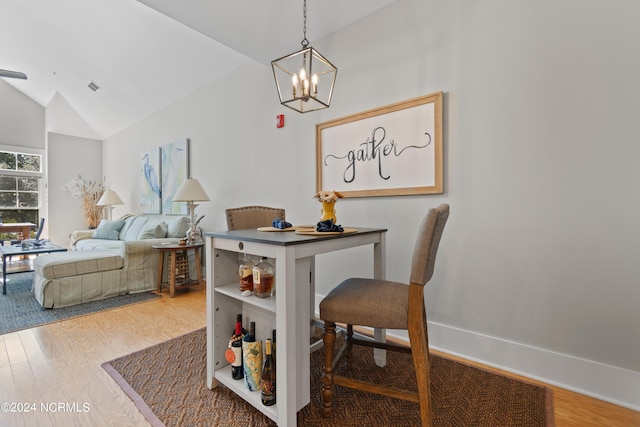 office area featuring a notable chandelier, wood-type flooring, and high vaulted ceiling