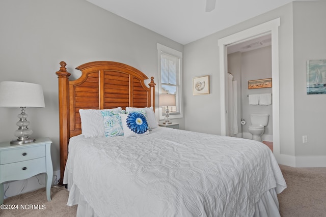 bedroom with light carpet, ensuite bathroom, and ceiling fan