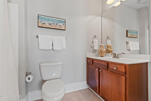 2537 St James Dr SE Unit 303, Southport, NC 28461 - bathroom featuring vanity, toilet, baseboards, and tile patterned floors