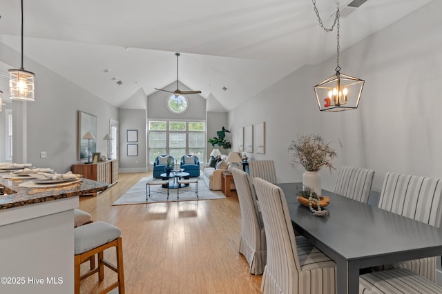 2537 St James Dr SE Unit 303, Southport, NC 28461 - dining space featuring light wood-type flooring, a chandelier, high vaulted ceiling, ceiling fan, and baseboards