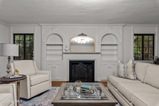 living room featuring hardwood / wood-style flooring, built in features, and a healthy amount of sunlight