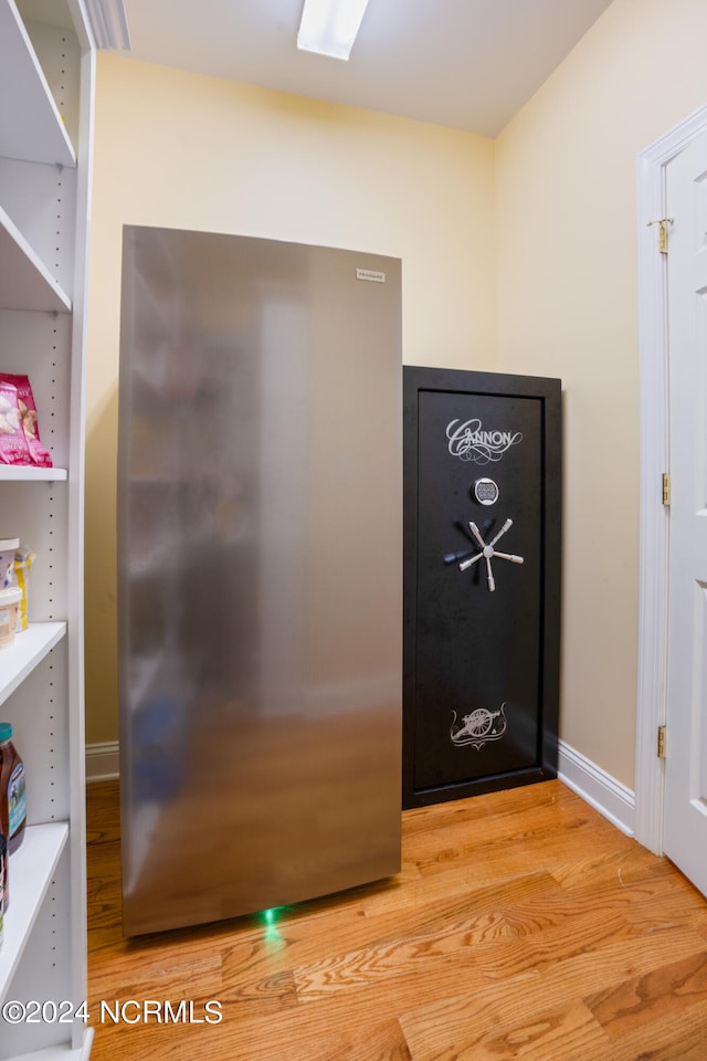 details with stainless steel fridge and hardwood / wood-style floors