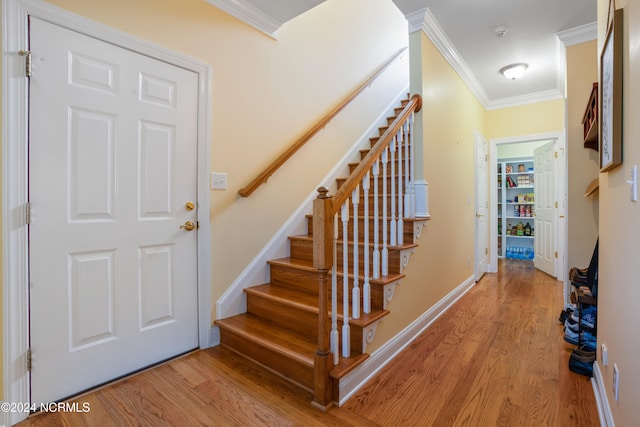 stairway featuring hardwood / wood-style flooring and crown molding