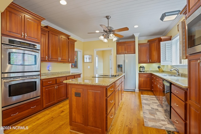 kitchen with black appliances, a center island, light hardwood / wood-style flooring, ornamental molding, and sink