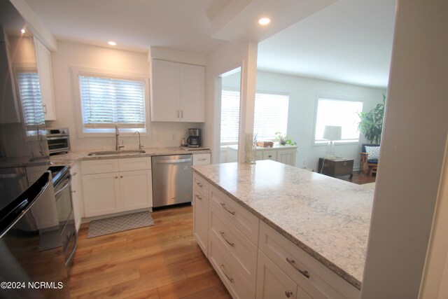 kitchen with white cabinets, dishwasher, light hardwood / wood-style flooring, and sink