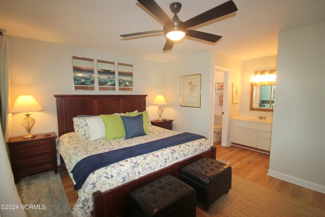 bedroom featuring light hardwood / wood-style floors, connected bathroom, sink, and ceiling fan