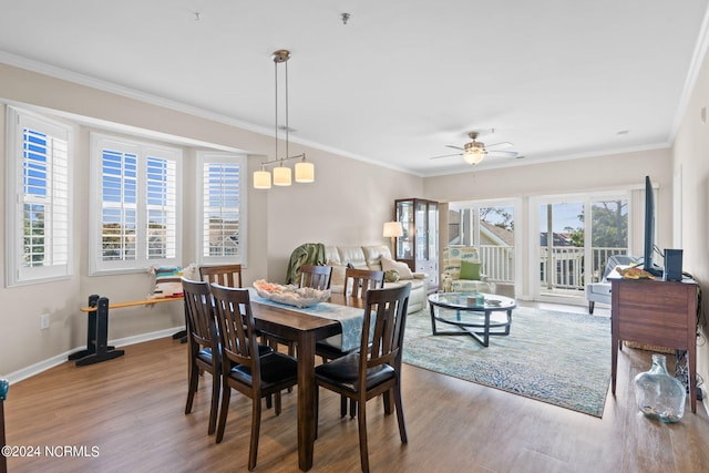 dining space with ornamental molding, wood-type flooring, and ceiling fan