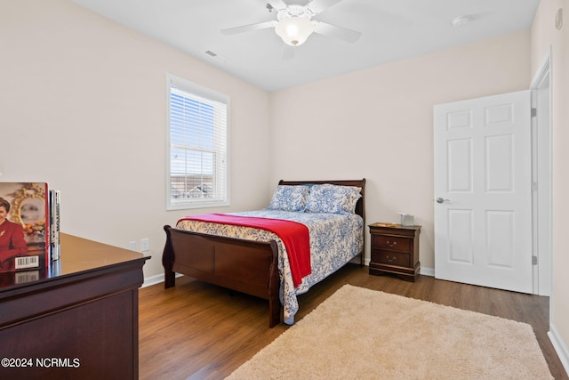 bedroom with dark hardwood / wood-style flooring and ceiling fan