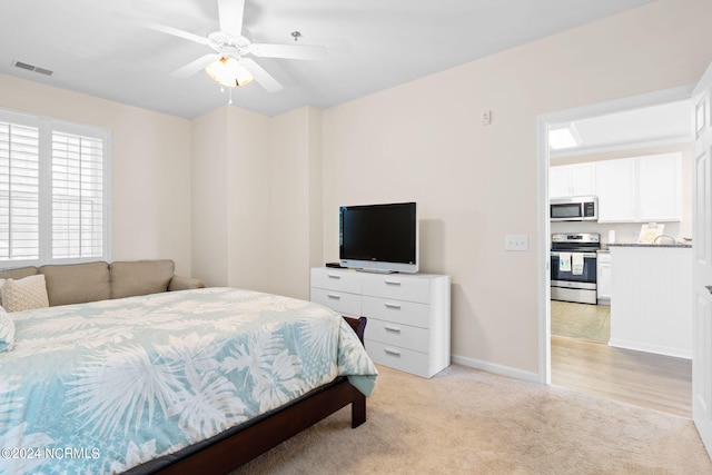 bedroom with ceiling fan and light carpet