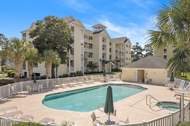 view of pool featuring a community hot tub and a patio area