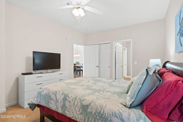 carpeted bedroom with ceiling fan and a closet