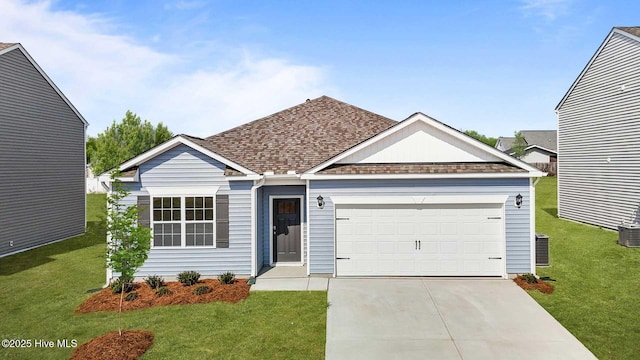 ranch-style home with concrete driveway, a garage, a front yard, and roof with shingles